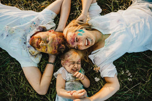Photo de la page d'accueil du site DJOSSYE - Famille dans l'herbe avec des tâches de peinture